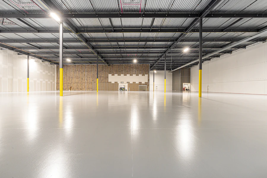 Bright empty warehouse interior with a polished concrete floor and yellow column guards