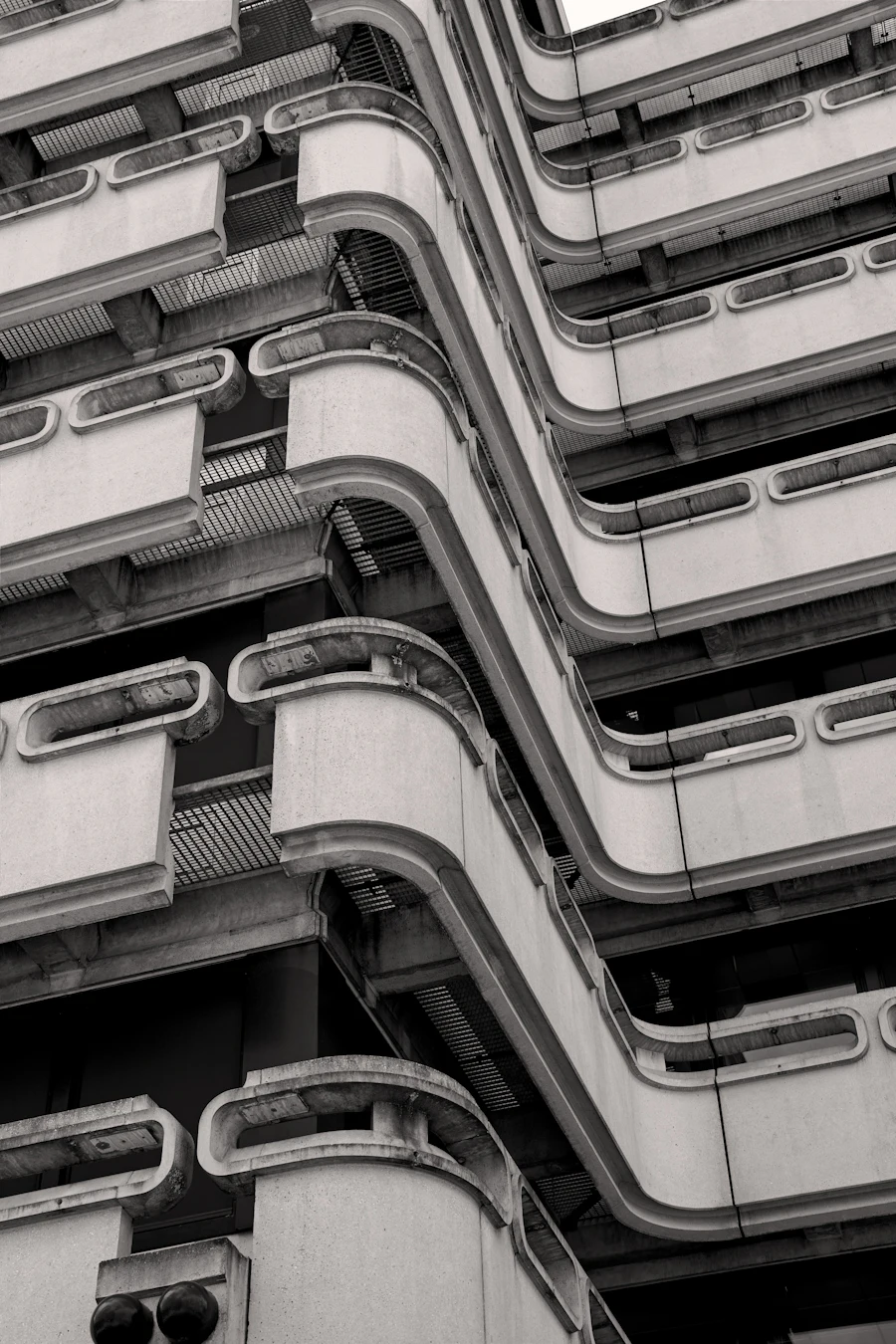 Curving concrete apartment balconies stacked floor upon floor, in black and white