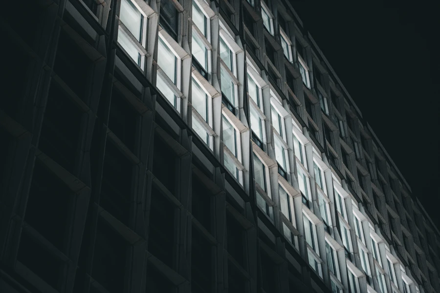 Dark office facade at night with a single lit strip of windows